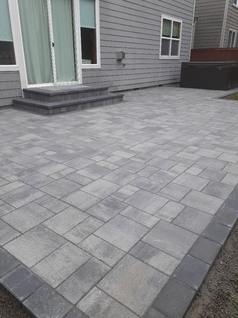 Gray paver patio with steps at back door in Seattle area